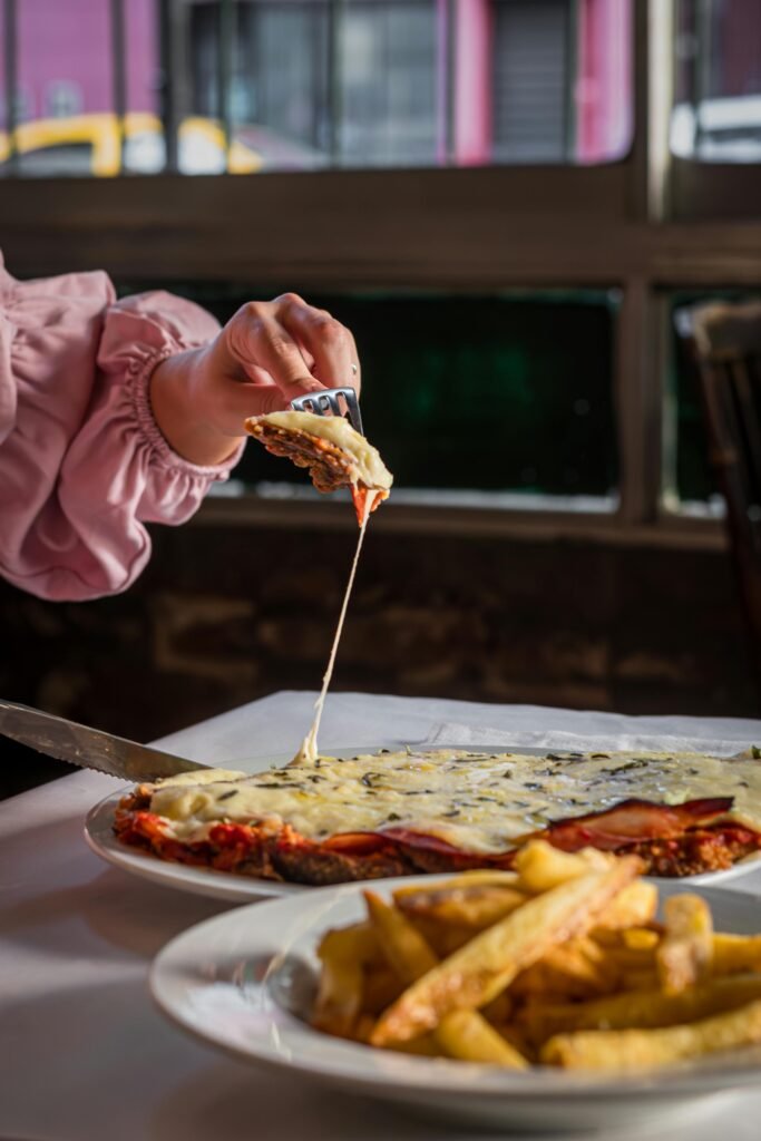 Delicious milanesa with melted cheese being served in Buenos Aires restaurant.