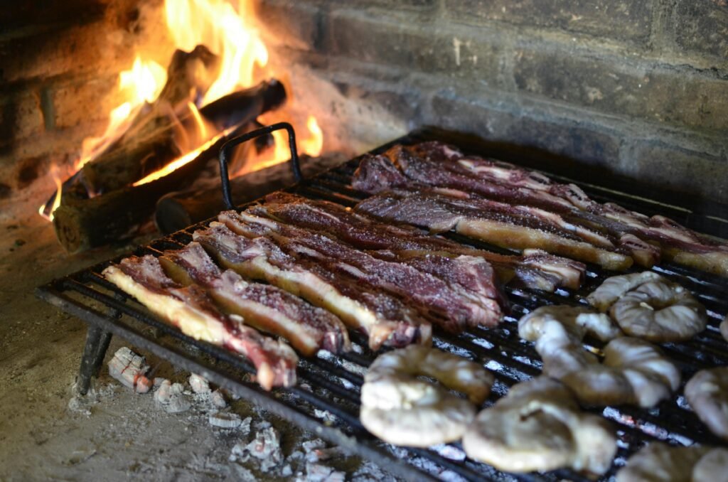 Juicy cuts of meat sizzling on a traditional Argentine grill with open flames.