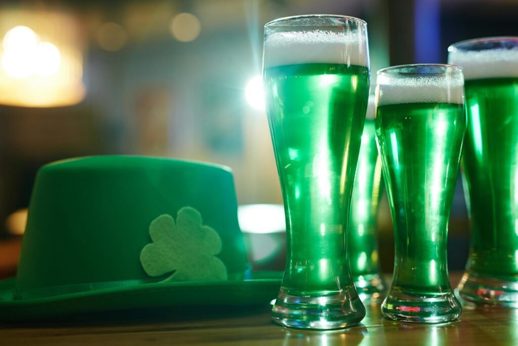 Vibrant green beers and shamrock hat symbolize a cheerful Saint Patrick's Day celebration indoors.