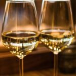 Two elegant wine glasses filled with white wine, captured with a beautiful bokeh effect.